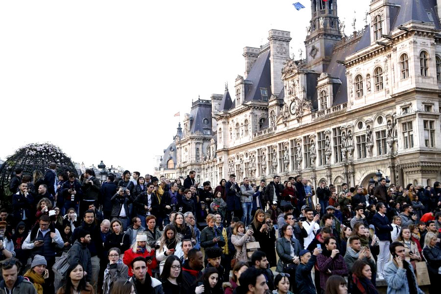 cittadini e turisti assistono al terribile spettacolo di Notre Dame che brucia
